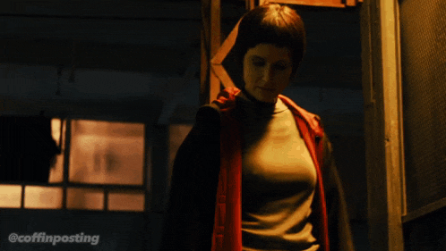 a man in a red jacket is standing in a dark room with the hashtag @coffinposting on the bottom