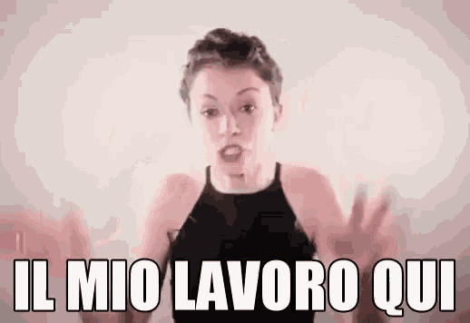 a woman in a black tank top is making a funny face and saying il mio lavoro qui .