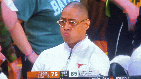 a man wearing glasses and a white jacket with a bull on it