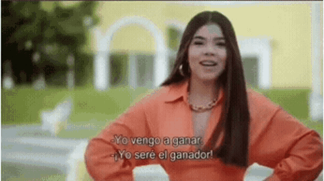 a woman in an orange shirt is talking in spanish