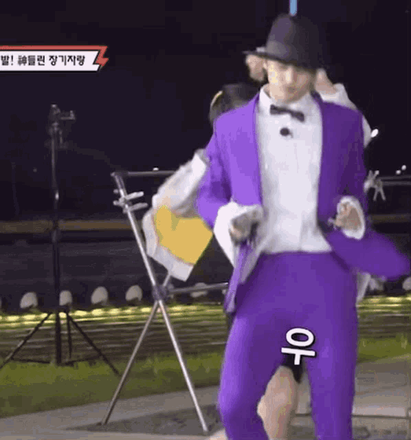 a man in a purple suit and top hat is holding a gun