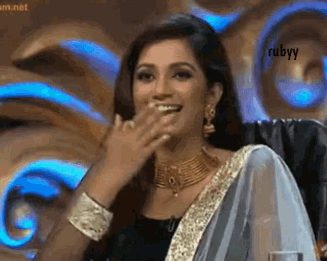 a woman covering her mouth with her hand and the word rubyy is on the bottom right