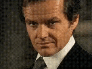 a close up of a man in a suit and tie making a serious face .