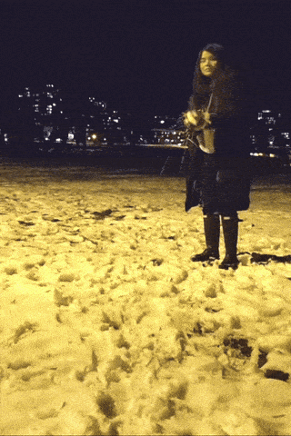 a woman standing in the snow at night