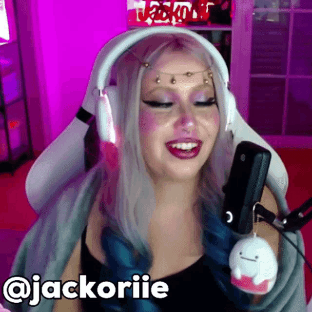 a woman is wearing headphones and smiling in front of a microphone with the name jackoriie written on the bottom