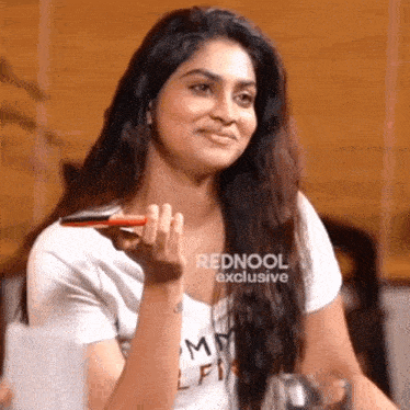 a woman wearing a white t-shirt that says tommy hilfiger on it