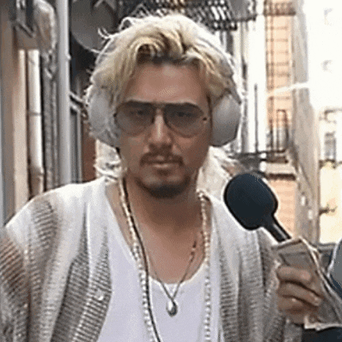 a man wearing headphones , sunglasses and a necklace is holding a microphone and money .