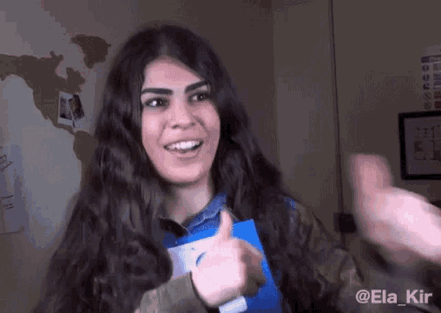 a woman giving a thumbs up with the name ela kir written on the bottom