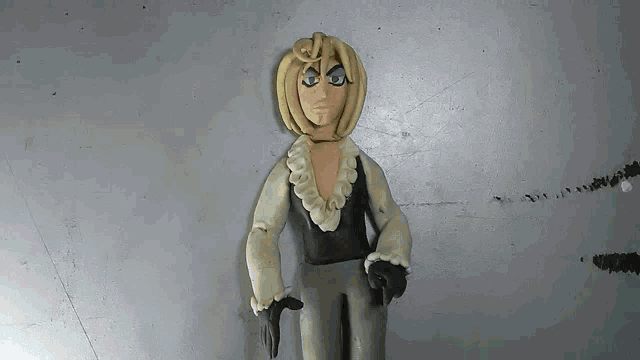 a clay figure of a man with blonde hair and a black shirt