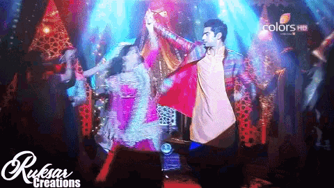 a man and a woman are dancing in front of a colors hd logo