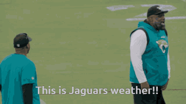 a man in a jaguars shirt is standing on a field
