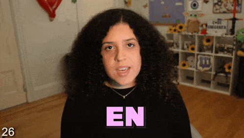 a woman with curly hair wearing a black shirt with the word en on it