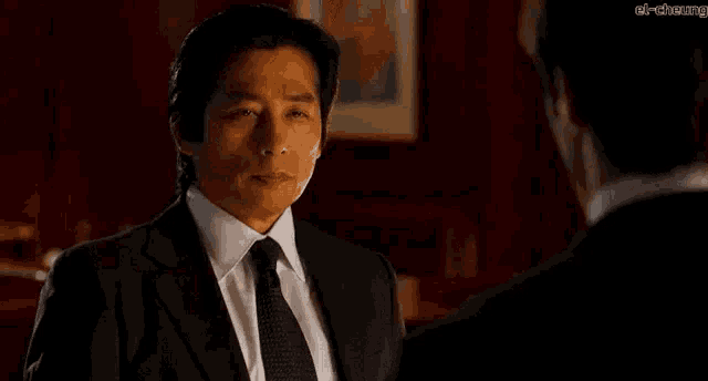 a man in a suit and tie is talking to another man in a suit and tie .