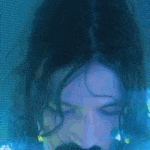a close up of a person 's face with a blue light behind it