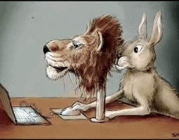 a lion and a rabbit are sitting at a desk looking at a laptop computer .