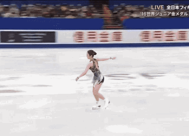 a woman is ice skating in front of a sign that says live on it .