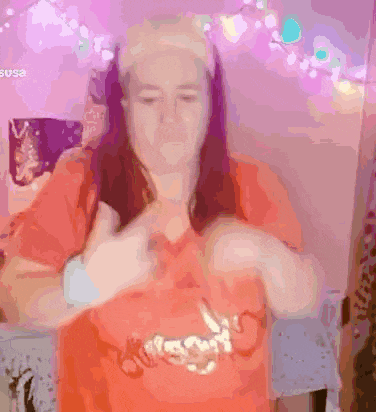 a woman wearing an orange shirt with the word susa on the front