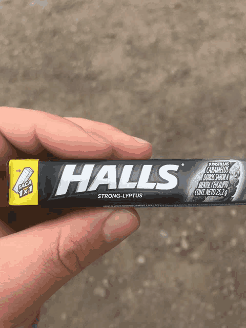 someone is holding a pack of halls strong-lyptus