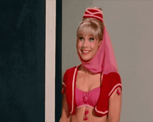 a woman in a pink costume is smiling while wearing a pink head scarf .