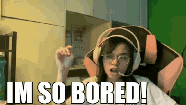 a woman wearing headphones says i 'm so bored while sitting in a chair