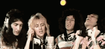 a group of people are singing into microphones while standing next to each other .