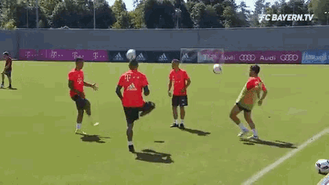 a group of soccer players are practicing on a field sponsored by audi and t-mobile .