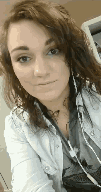 a close up of a woman wearing headphones and a white shirt