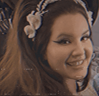 a woman wearing a headband with a flower on it is smiling .