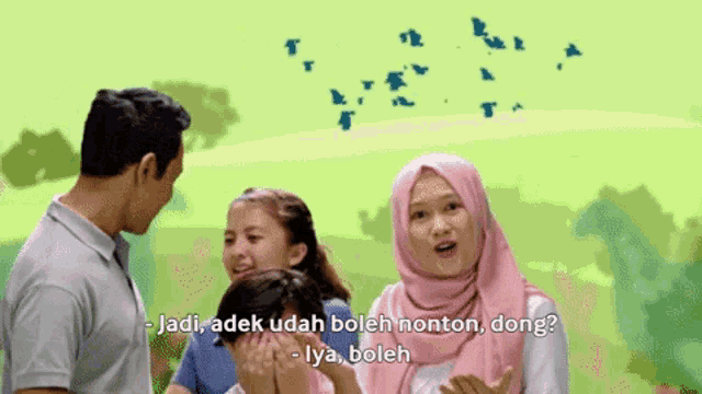 a woman in a pink hijab talks to a man and a girl