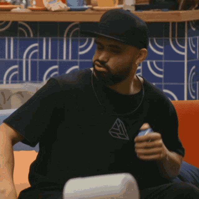 a man with a beard wearing a hat and a black shirt