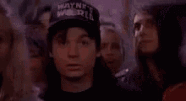 a man in a hat is standing in a crowd of people and smiling .