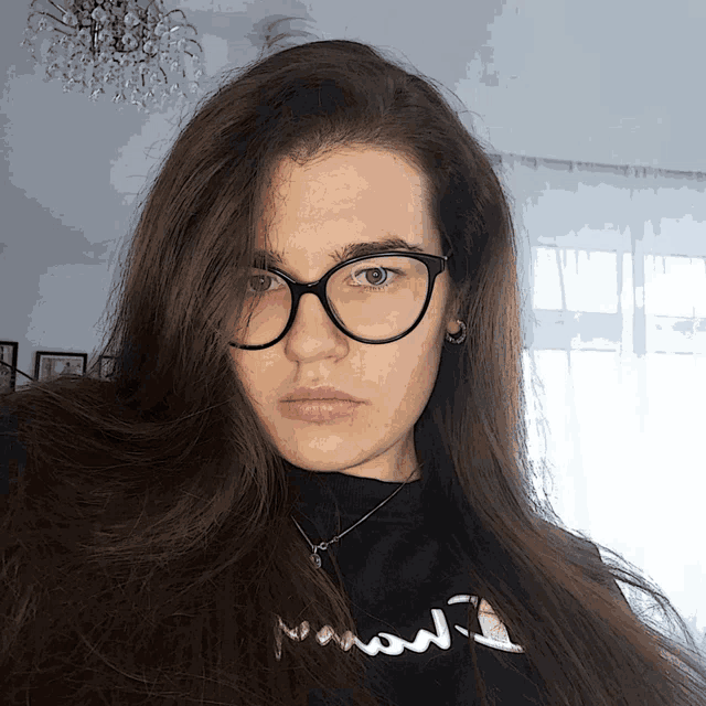 a woman wearing glasses and a black shirt that says ' i love you ' on it