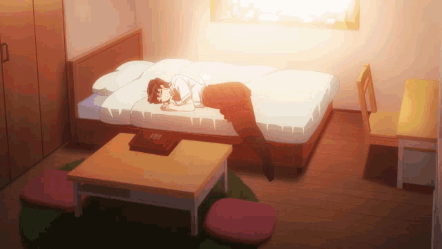 a girl is laying on a bed in a room with a table and chair