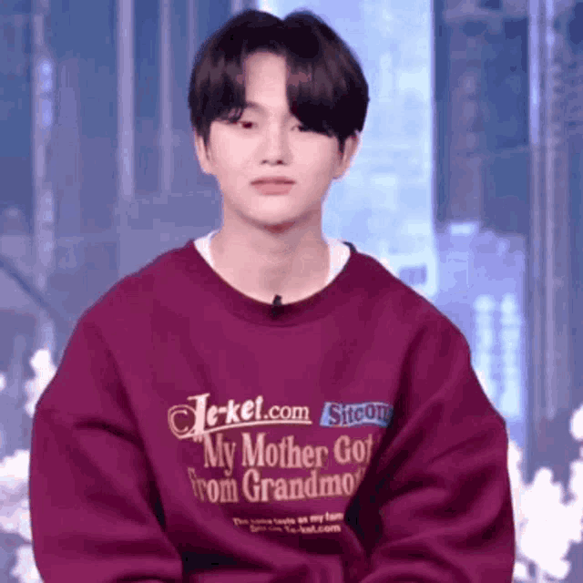 a young man wearing a purple sweater that says my mother got from grandma