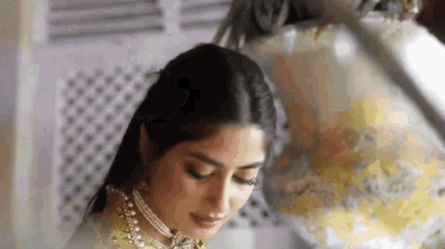 a close up of a woman wearing a pearl necklace and earrings in front of a globe .