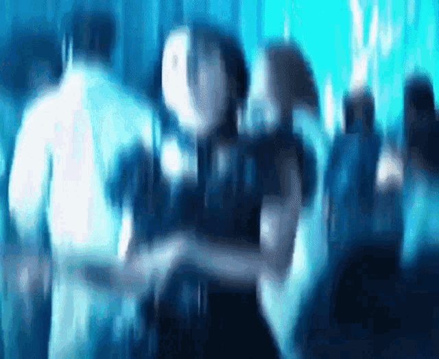 a blurry picture of people dancing in a club
