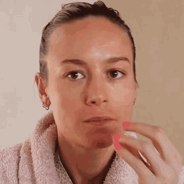 a woman with a pink towel around her neck is making a funny face