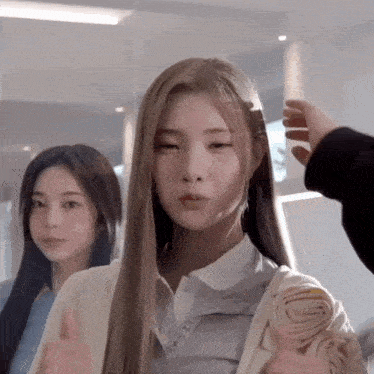 a woman with long blonde hair is getting her hair styled by a person .