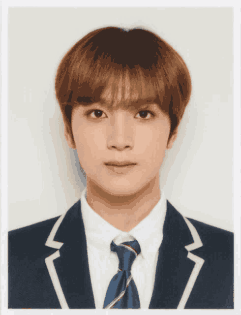 a young man in a suit and tie is looking at the camera