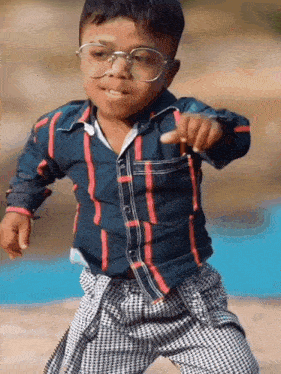 a young boy wearing glasses and a striped shirt is pointing at the camera