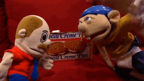 two stuffed animals standing next to a box of real creme pies