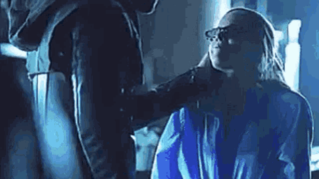 a man is putting his hand on a woman 's neck .