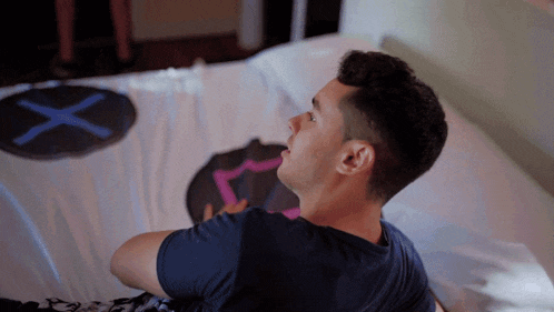 a man is laying on a bed with a x on it