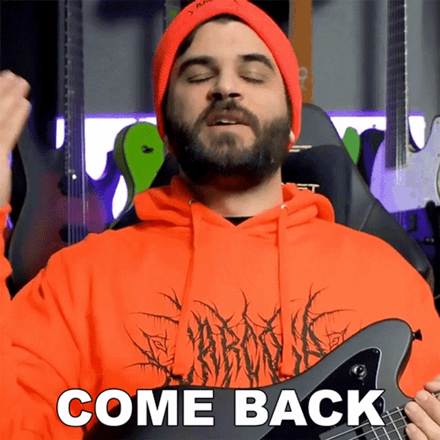 a man wearing an orange hoodie and a red beanie is holding a guitar and saying come back