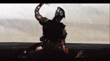 a man is laying on the ground in the snow with his arm up