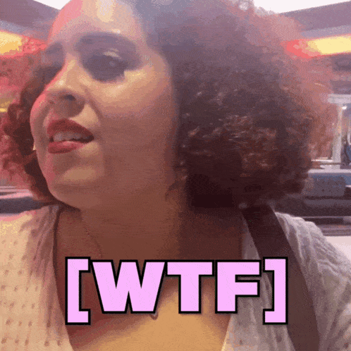 a woman with curly hair has the word wtf on her chest