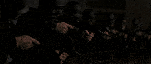 a group of soldiers are firing their guns in a dark room