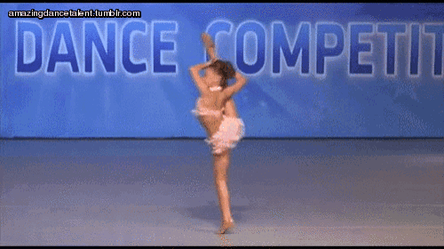 a woman is doing a split in front of a sign that says dance competiti
