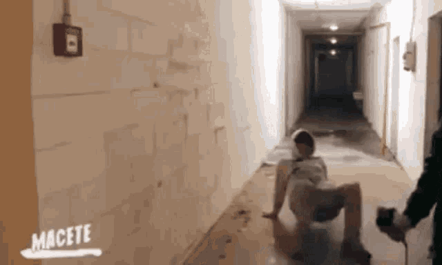 a person is laying on the floor in a hallway with the word macete written on the bottom