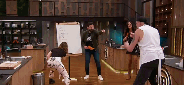 a group of people dancing in front of a white board
